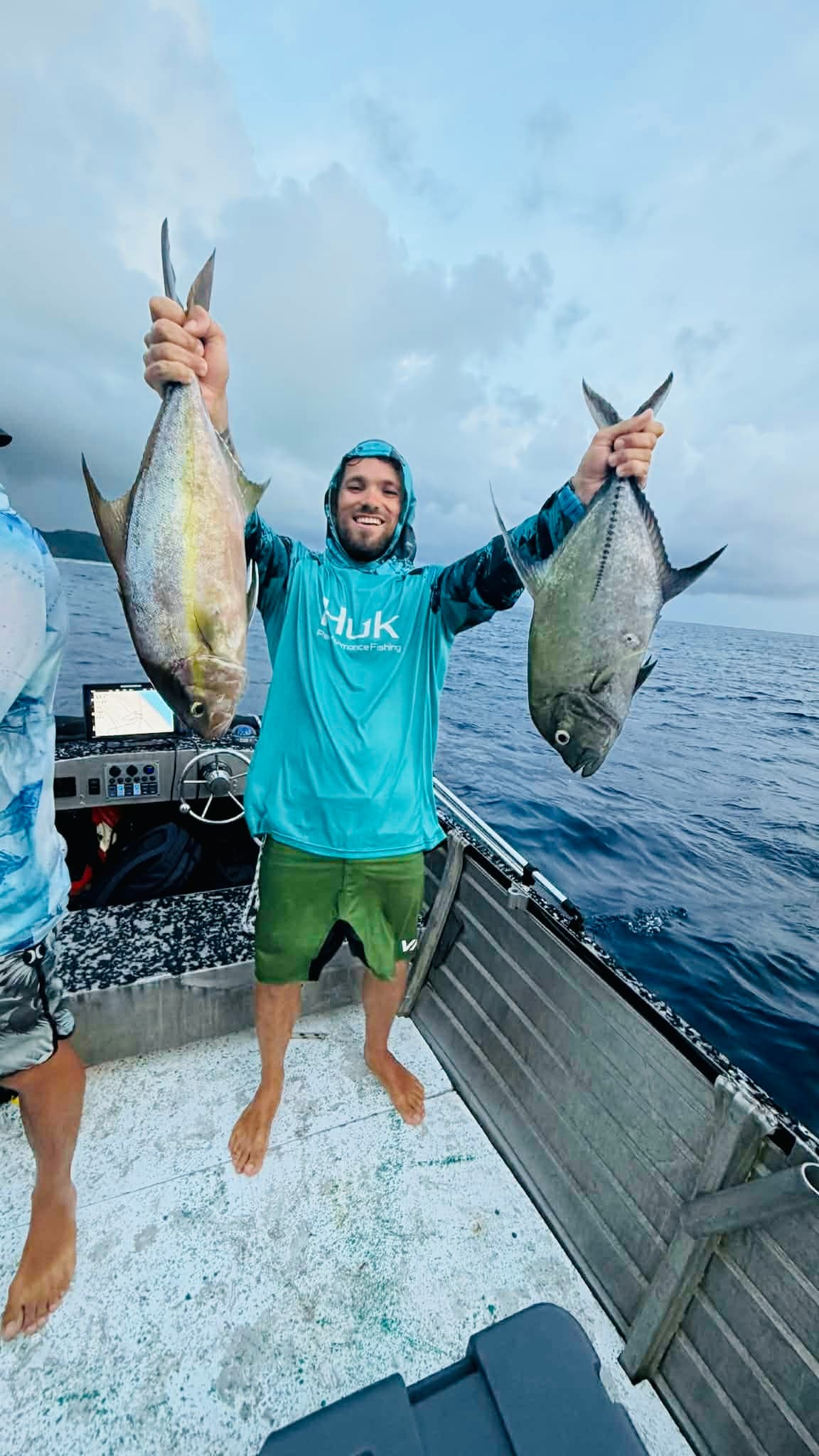 Fishing: Angler holding a pair of trevally on deck
