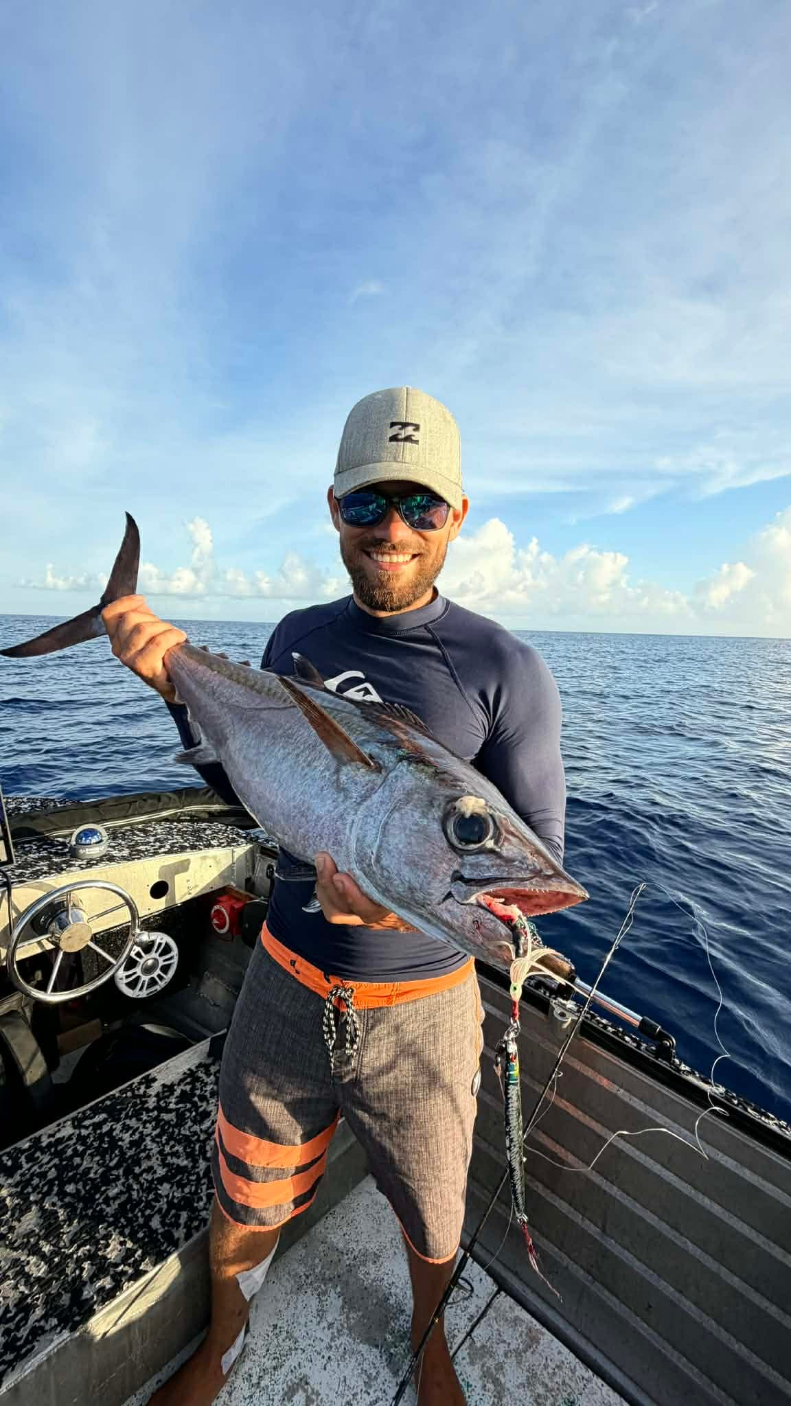 Fishing: Angler with a dogtooth tuna in the evening light